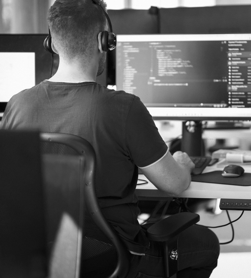 AI security engineer sitting at his desk and reviewing code on his computer AI security engineer sitting at his desk and reviewing code on his computer